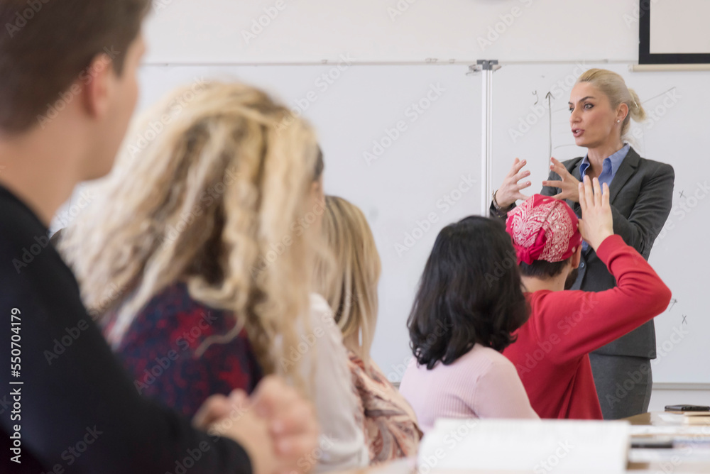 Female teacher or professor giving a lecture in a classroom Female teacher or professor giving a lecture in a classroom