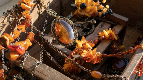 Fotografie Different Baltic amber jewelry lying on an old wood clockwork