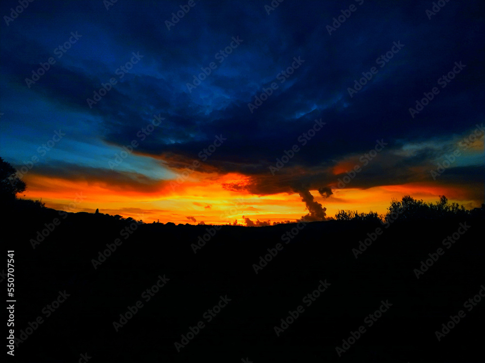 Red-orange sunset with blue-toned clouds