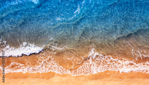 Fototapeta Naklejka Na Ścianę i Meble -  Turquoise water wave with sand beach background from aerial top view. Concept summer sunny travel image