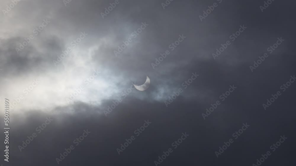 A solar eclipse in cloudy weather through a cloud. partial solar eclipse. A solar eclipse in cloudy weather through a cloud. partial solar eclipse.