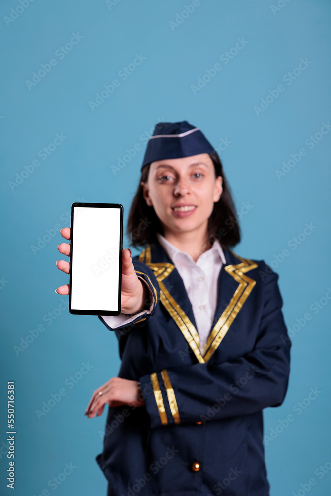 Smiling flight attendant showing modern phone with blank white screen, smartphone app advertising mockup. Plane air hostess holding telephone with empty display for web promotion Smiling flight attendant showing modern phone with blank white screen, smartphone app advertising mockup. Plane air hostess holding telephone with empty display for web promotion