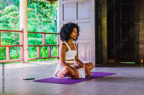 Afro yoga instructor doing poses in teaching class