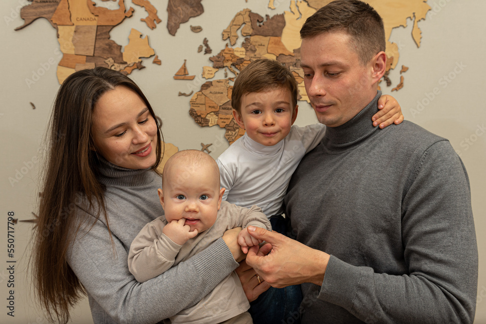 portrait of a young family, father, mother and two small sons, cheerful, friendly and strong family. They smile and hug children in their arms. The concept of a young friendly family portrait of a young family, father, mother and two small sons, cheerful, friendly and strong family. They smile and hug children in their arms. The concept of a young friendly family