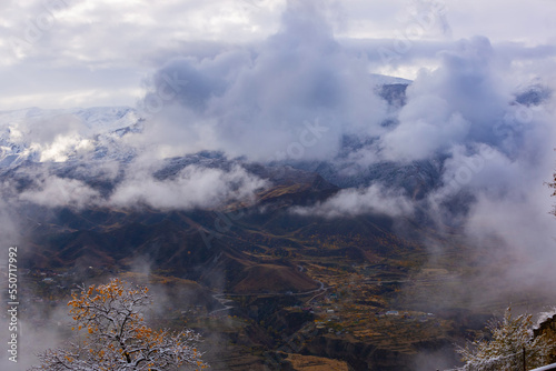 Panoramic view from the Gunib village  Dagestan  Russia. Snow-capped mountains and winter forest. Beautiful mountain landscape in winter. Foggy forest hills