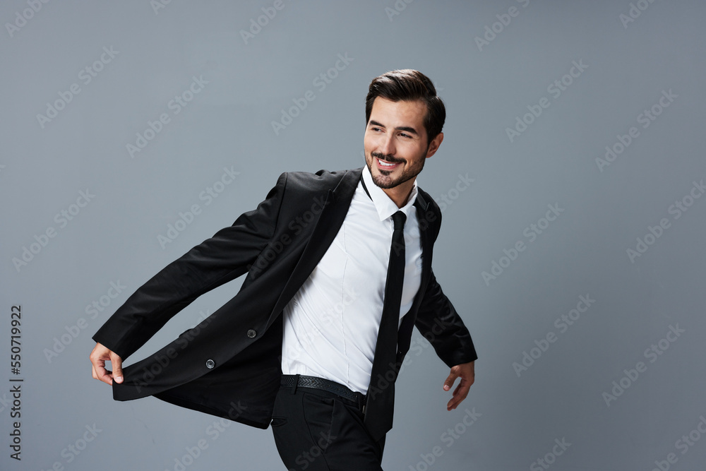 Business man in jacket and shirt jumps and runs on gray background raised hands up smile with teeth Business man in jacket and shirt jumps and runs on gray background raised hands up smile with teeth