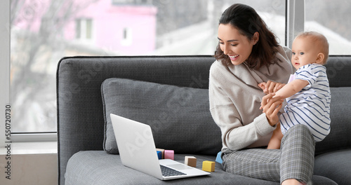 Young working mother with her baby in office