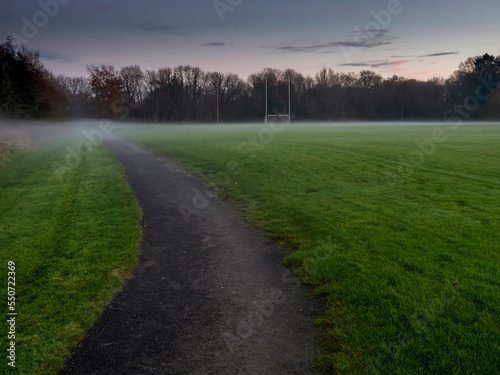 Irish National sport ground wit tall goal posts for camogie  hurling  rugby  Gaelic football at dusk and low fog over the ground. Calm and peaceful mood. Sport activity concept.