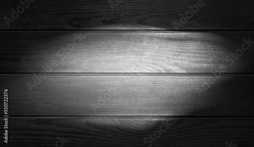 Backlight on black wooden texture as background