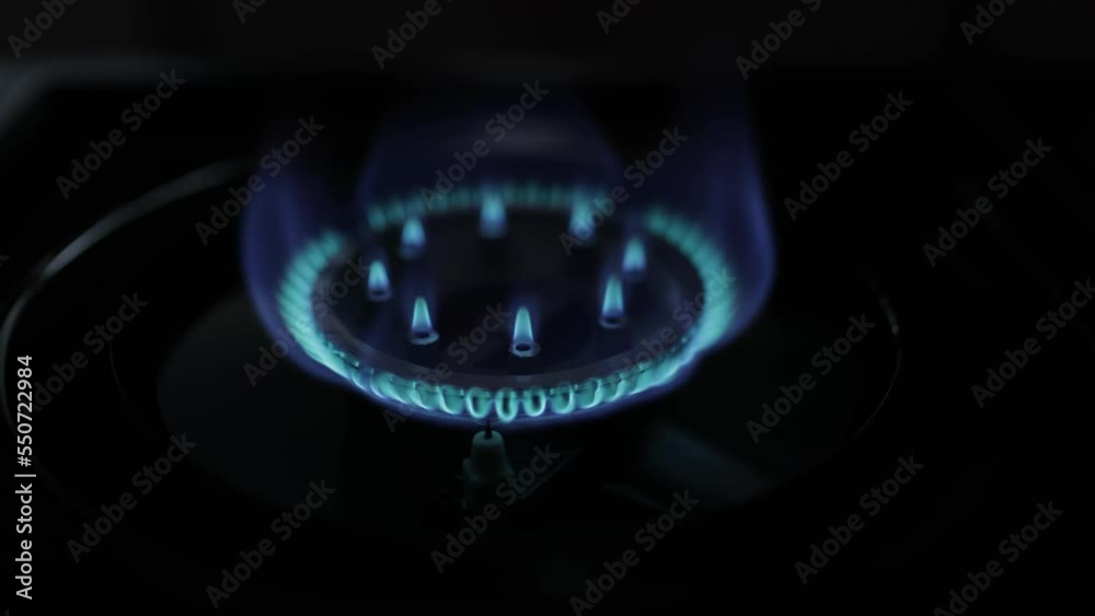Natural gas blue fire flame on kitchen burner gas stove on dark background. Circular gas-jet. Flame Gas Burner Operation. Shortage and gas crisis Natural gas blue fire flame on kitchen burner gas stove on dark background. Circular gas-jet. Flame Gas Burner Operation. Shortage and gas crisis