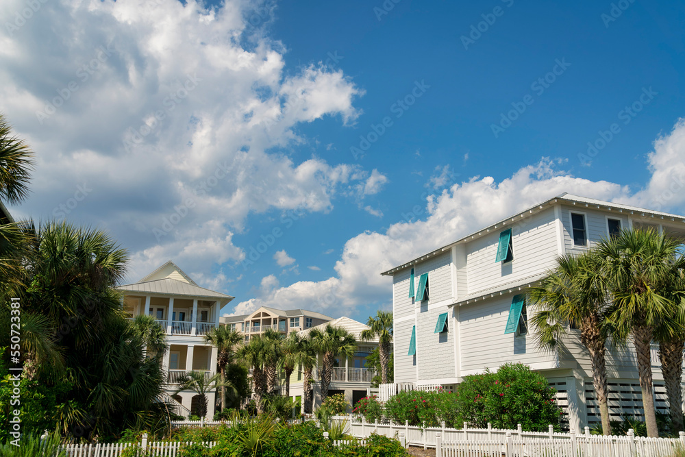 Destin, Florida- Views of large residential houses with picket fence and palm trees Destin, Florida- Views of large residential houses with picket fence and palm trees