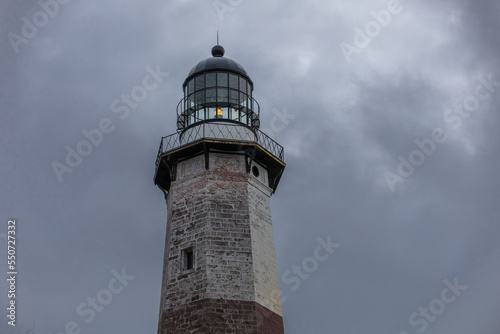 Montauk Point Lighthouse at Montauk State Park in East Hampton, Long Island, New York. The tower is under construction awaiting new paint. Storm clouds above