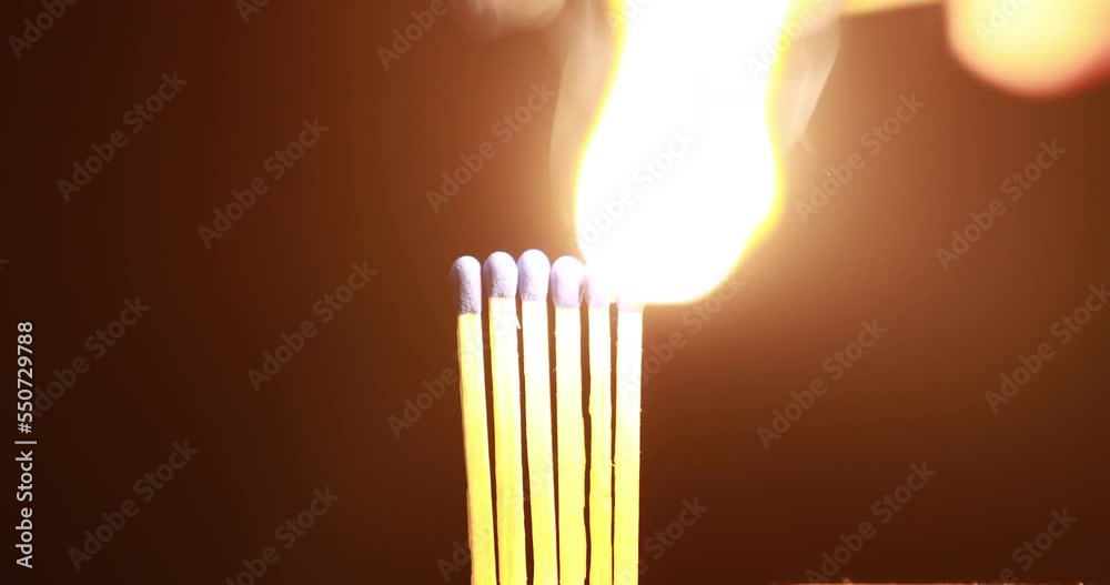 man hand holds wooden match with a sulphur head ignites another ...