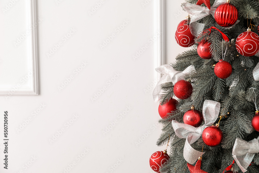 Decorated Christmas tree near light wall, closeup фотография Stock
