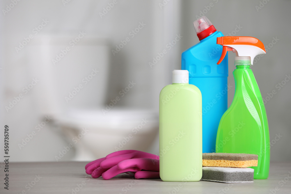Cleaning supplies on table in bathroom, space for text Cleaning supplies on table in bathroom, space for text