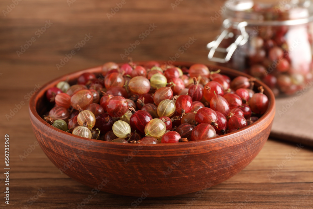 Bowl full of ripe gooseberries on wooden table, closeup Bowl full of ripe gooseberries on wooden table, closeup