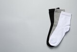 Different socks on light grey background, flat lay. Space for text
