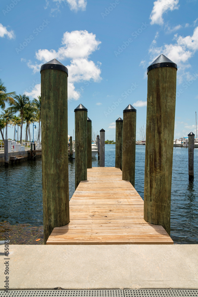 Vertical shot of a wooden dock with log posts at the bay in Miami, Florida