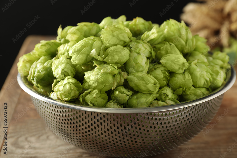 Fresh green hops in sieve on table, closeup Fresh green hops in sieve on table, closeup