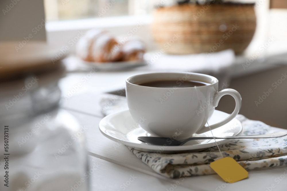 Tea bag in cup on white wooden table indoors. Space for text Tea bag in cup on white wooden table indoors. Space for text