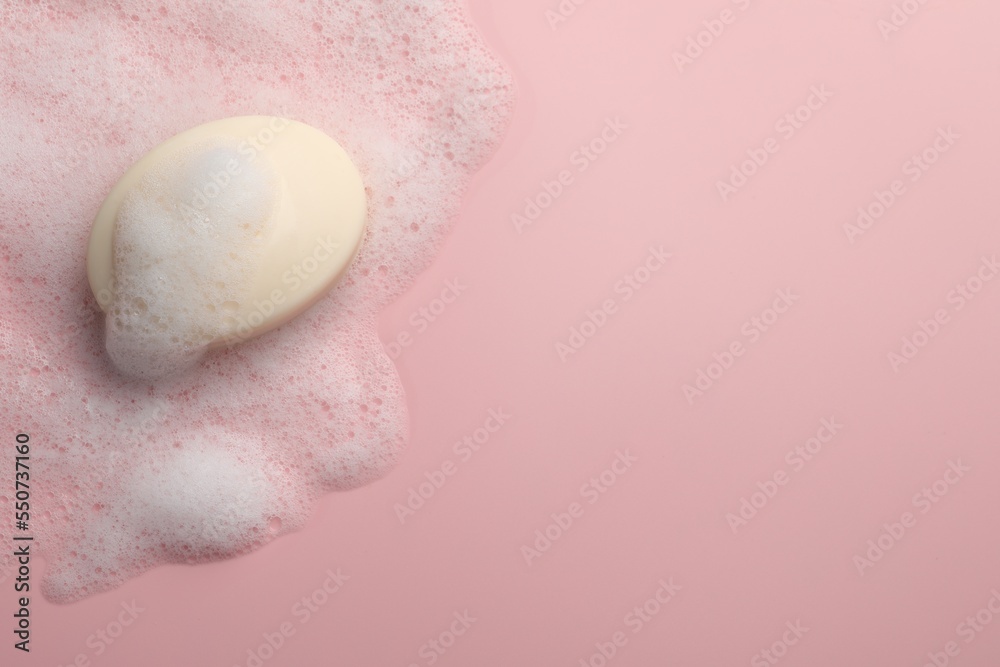 Soap with fluffy foam on pink background, top view. Space for text Soap with fluffy foam on pink background, top view. Space for text
