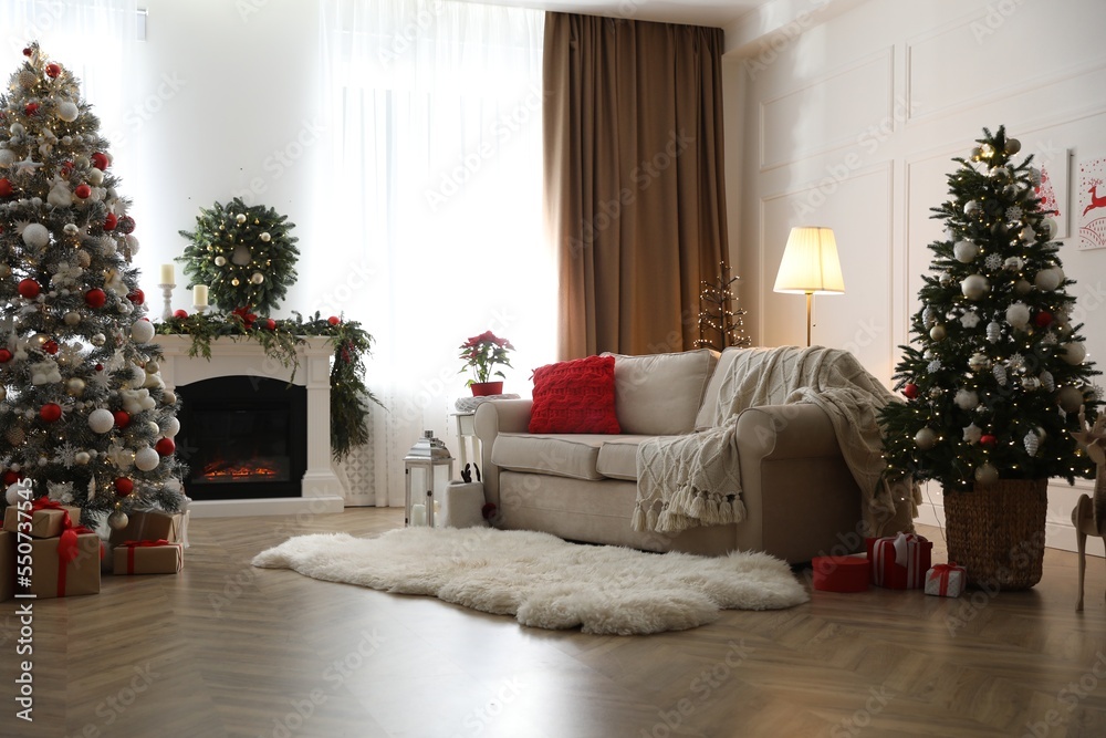Fototapeta premium Festive living room interior with Christmas trees and fireplace