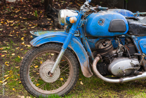 Old motorcycle in the yard side view. Rusty motorcycle in the yard