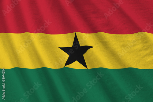 Ghana flag with big folds waving close up under the studio light indoors. The official symbols and colors in fabric banner photo