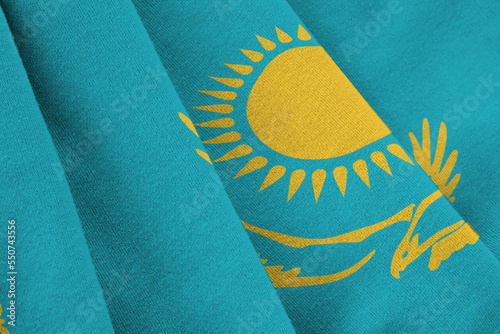 Kazakhstan flag with big folds waving close up under the studio light indoors. The official symbols and colors in fabric banner photo