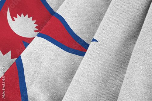 Nepal flag with big folds waving close up under the studio light indoors. The official symbols and colors in fabric banner photo