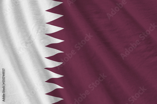 Qatar flag with big folds waving close up under the studio light indoors. The official symbols and colors in fabric banner photo