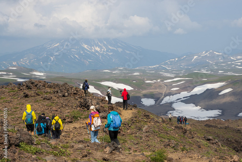 Hikers on a mountain path. View from Gorely volcano to Vilyuchinsky volcano, Kamchatka Krai, Far East of Russia. Travel and tourism on the Kamchatka Peninsula. Hiking in the wilderness photo