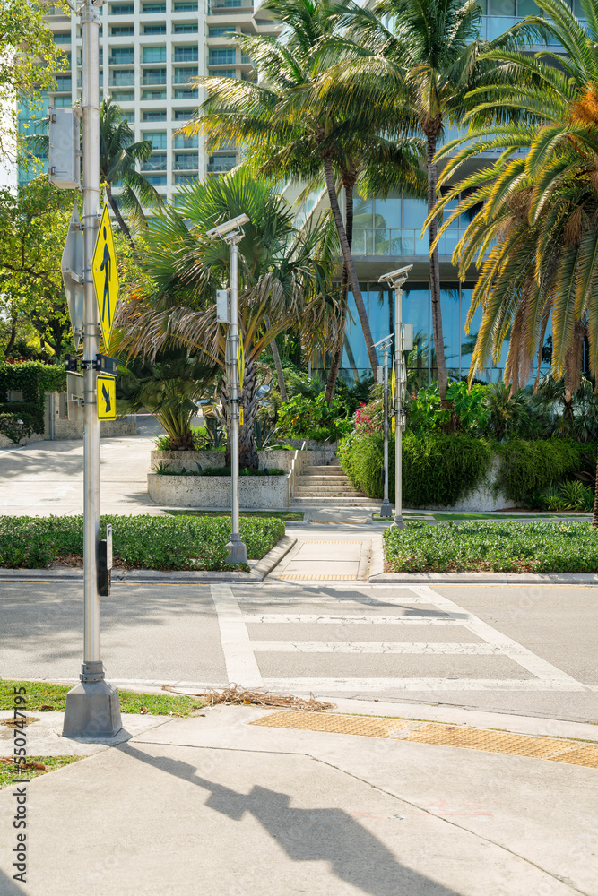 Crosswalk with yellow signs on the post at the side in Miami, Florida