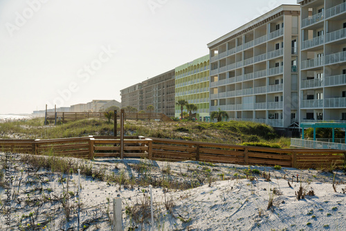 Hotel buildings with wood pathways on a white sand dunes outdoors in Destin, Florida © Jason