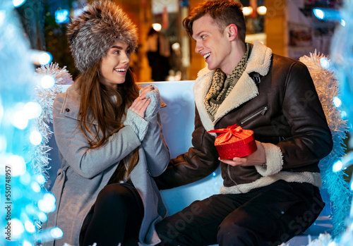 Canvas Print Beautiful young couple sitting in decorated carriages in the city, romantic nigh