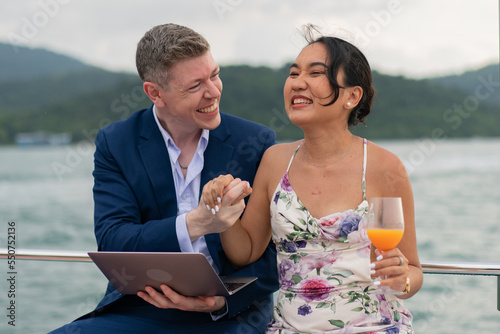 Caucasian businessman and businesswoman working outdoor together on digital tablet for online corporate. Two luxury business people working with laptop on a sailing boat. Concept business travel © kongga studio