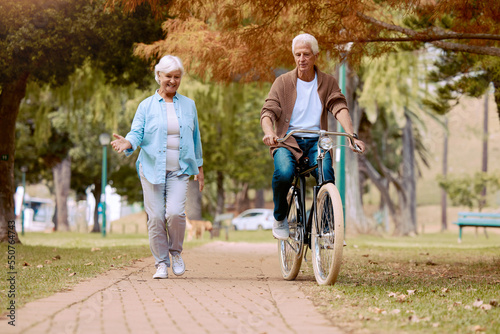 Senior couple, walking and bike at park, talking and bonding together mock up. Love, retirement and elderly man cycling on bicycle with happy woman speaking outdoors for exercise, health and wellness