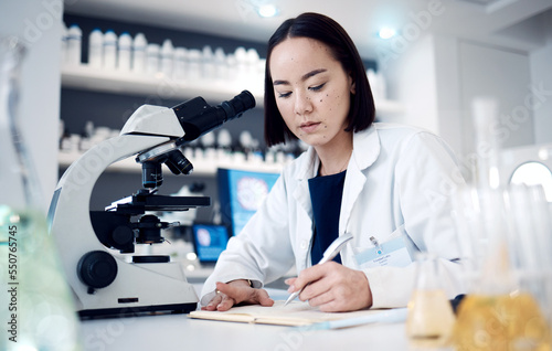 Science  chemistry research notebook and scientist writing chemical engineering report for pharmaceutical medicine development. Innovation  microscope and Asian woman working on laboratory analysis