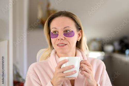 Woman with eye patches holding a cup of coffee