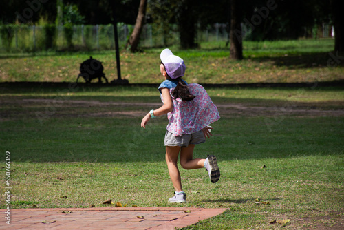 Life and lifestyle of asian girl children people running playing on grass floor garden park of Wat Si Chum temple and Pra Ajana buddha in Sukhothai Historical Park in World Heritage Site at Thailand photo
