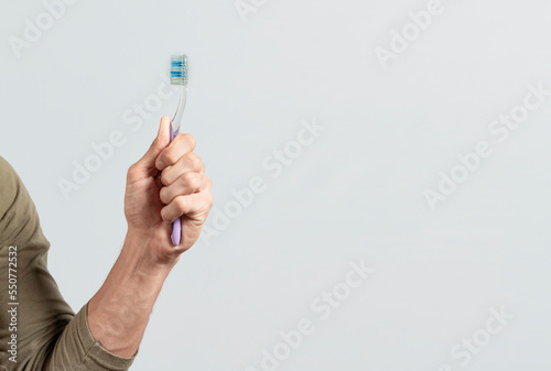 Hand holding toothbrush isolated on white. Male hand showing a toothbrush isolated. Toothbrush concept.