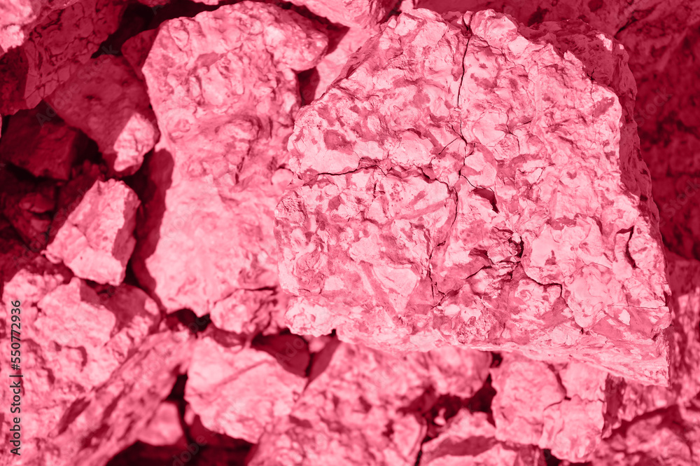 The texture of a pile of limestone stones Tinted image, color of the year 2023 viva magenta