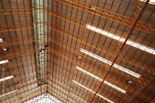 Steel roof structure of the gymnasium. Detail of steel roof structure with transparent tile strips and roof ventilation system in bottom view with copy space and focus.