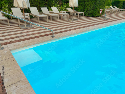 Outdoor swimming pool in luxury hotel on sunny summer day. Time for relax