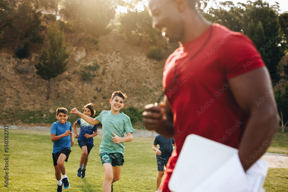 Children running on a school ground during PE Children running on a school ground during PE