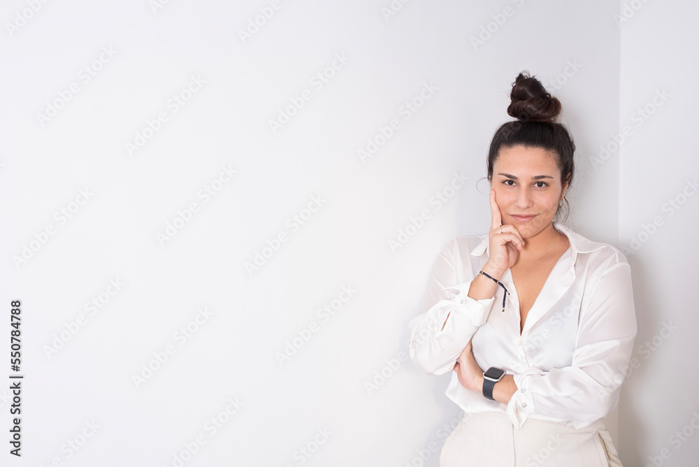 portrait on white wall of an empowered young woman in white executive clothes portrait on white wall of an empowered young woman in white executive clothes