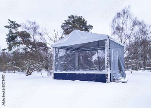 An empty scene in a winter park during a snowfall. Preparing for the festive Christmas concerts.
