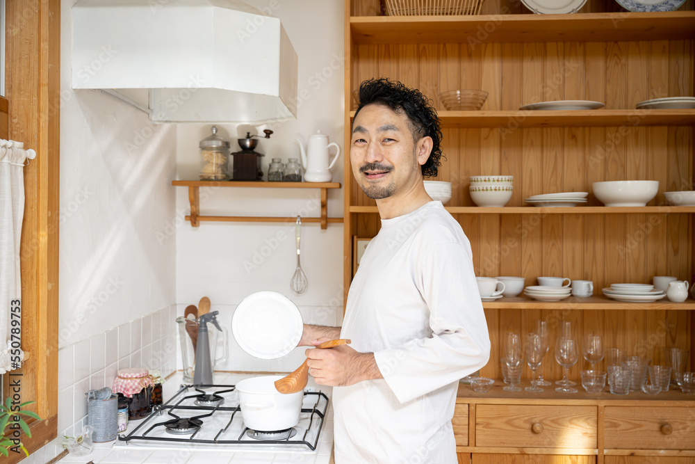 Asian man cooking in the kitchen Asian man cooking in the kitchen