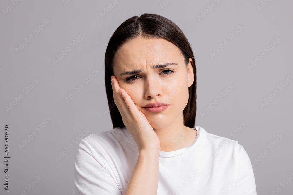 Close up shot selective focus portrait of sad young desperate woman holding hand near head cried suffers from domestic volatile abuse. Close up shot selective focus portrait of sad young desperate woman holding hand near head cried suffers from domestic volatile abuse.