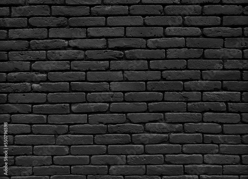 Black vintage brick wall texture background. Close up of old grunge brick tiles.